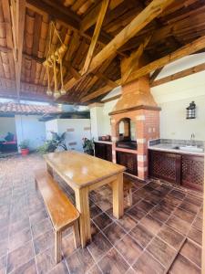 kuchnia z drewnianym stołem oraz piec ceglany w obiekcie Cabañas Marroquin 1 w mieście Copán