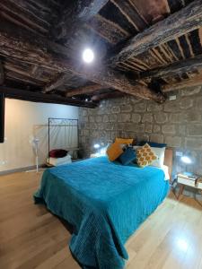 a bedroom with a blue bed in a stone wall at Il Paradosso Suite in Viterbo