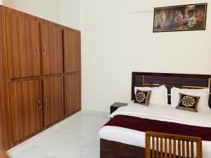 Un dormitorio con una cama grande y armarios de madera. en Zora Park Luxury Rooms, en Visakhapatnam