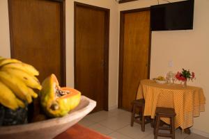 a dining room with a table and a bowl of fruit at Trindade Hospeda - Casinha Praia Ranchos in Trindade