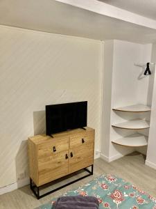 un salon avec une télévision sur un meuble en bois dans l'établissement Studio hyper centre de Beauvais, à Beauvais