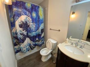 La salle de bains est pourvue de toilettes et d'un rideau de douche. dans l'établissement Calming 1bedroom Units With Balcony And City View, à Edmonton