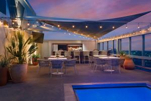 un patio en la azotea con mesas y sillas y una piscina en Omni Austin Hotel Downtown, en Austin