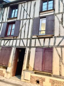 um edifício antigo com janelas e portas fechadas com tábuas em Studio hyper centre de Beauvais em Beauvais