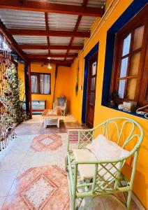 uma sala de estar com paredes e cadeiras amarelas e uma mesa em Hospedaje Flores del Sur em El Calafate