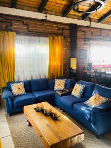 a living room with blue couches and a coffee table at Cabañas Marroquin 2 in Ostumán