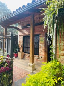 a brick building with a wooden pergola at Cabañas Marroquin 2 in Ostumán