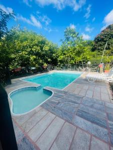 a swimming pool with blue water and trees at Cabañas Marroquin 2 in Ostumán