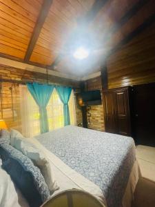 OstumánにあるCabañas Marroquin 2のベッドルーム1室(青いカーテン付きの大型ベッド1台付)