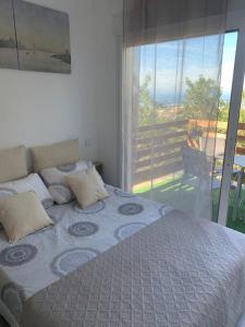 Schlafzimmer mit einem Bett und Blick auf einen Balkon in der Unterkunft Apt Verduron haut vue Mer "La maison du ch K" in Marseille