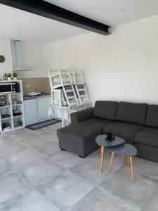 ein Wohnzimmer mit einem Sofa und einem Tisch in der Unterkunft Apt Verduron haut vue Mer "La maison du ch K" in Marseille