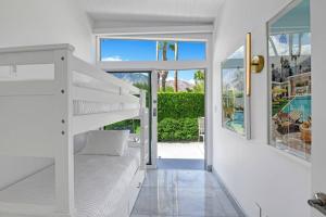 ein weißes Schlafzimmer mit einem Etagenbett und einem Pool in der Unterkunft Palm Springs Luxury Home With Pool and Next to Downtown & Airport in Palm Springs