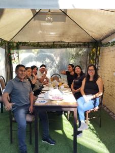 a group of people sitting around a table in a tent at hospedaje kayros in Arequipa