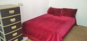 1 dormitorio con cama roja y vestidor en maison de paix, 
