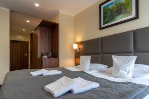 a hotel room with a large bed with towels on it at Hotel Wodnik in Bydgoszcz