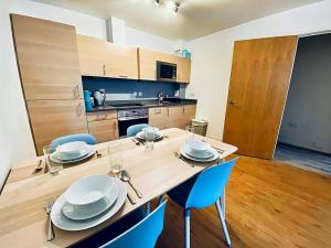 a kitchen with a table and blue chairs in a room at Secure 2BR 1BA Apartment for 6 in Colindale