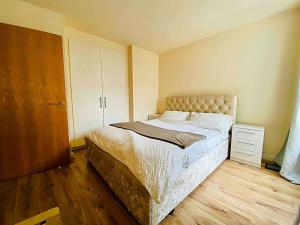 a bedroom with a bed and a wooden floor at Secure 2BR 1BA Apartment for 6 in Colindale