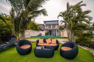 a backyard with two chairs and a couch on the grass at Ocean Pearl Phangan in Baan Tai