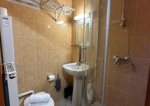 ein Bad mit einem WC, einem Waschbecken und einer Dusche in der Unterkunft Hôtel Victor Hugo in Aubervilliers
