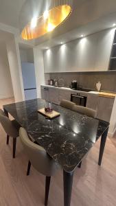 a kitchen with a black marble table and chairs at Queen 4 in Belgrade