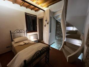 een slaapkamer met een bed en een wenteltrap bij casatorre medioevale in Campi Bisenzio