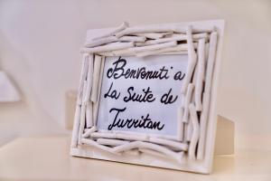 een bord in een witte rieten mand met een bord dat prachtig een dobbelsteen leest bij LA SUITE DE TURRITAN in Sassari