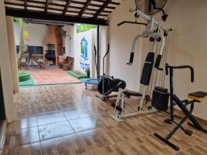 einen Fitnessraum mit Laufbändern und Trainingsgeräten in einem Zimmer in der Unterkunft Hostal Lo de Tote in Villa Concepción