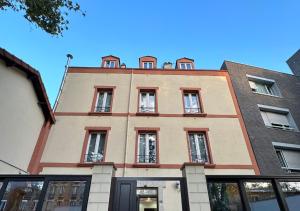 un bâtiment avec des fenêtres au-dessus dans l'établissement Hôtel Victor Hugo, à Aubervilliers