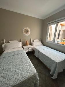 因赫尼奧的住宿－Casa Daniella Vivienda A，一间卧室设有两张床和窗户。