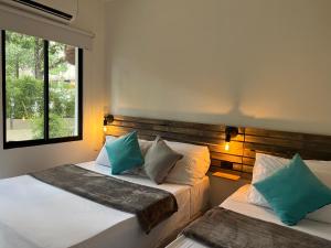 two beds in a room with a window at HOTEL 9.5 SAN FERNANDO in Cali +196 photos