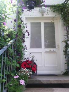 uma porta branca com flores em frente a uma casa em Pension TimeOut em Kassel