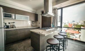 uma cozinha com um balcão e alguns bancos em Wisconsin 68 PH1 · Brand New PH with Private Rooftop @ WTC em Cidade do México