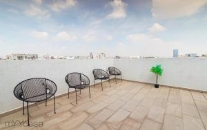4 sillas en un balcón con vistas a la ciudad en Wisconsin 68 PH1 · Brand New PH with Private Rooftop @ WTC en Ciudad de México