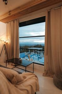 a bedroom with a large window with a view of a pool at Calm House Villa in Prijedor