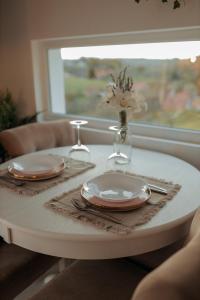 een tafel met twee borden en een vaas met bloemen erop bij Calm House Villa in Prijedor