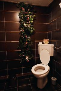 a bathroom with a toilet with a christmasreath on the wall at Calm House Villa in Prijedor