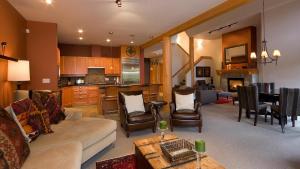 ein Wohnzimmer und eine Küche mit einem Sofa und einem Tisch in der Unterkunft Goldenwood 8336 - Large Townhouse, Golf Course Views, Hot Tub, Patio - Whistler Platinum in Whistler