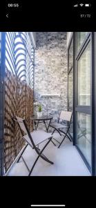 two chairs and a table in a room with a stone wall at Exquisite studio apartment with an original design in Valencia
