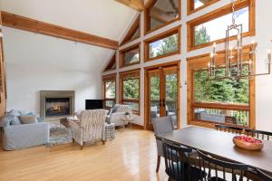 a living room with a table and chairs and a fireplace at Meadow Green Chalet - Family Chalet, Golf Course, Hot Tub, BBQ, Garden - Whistler Platinum in Whistler