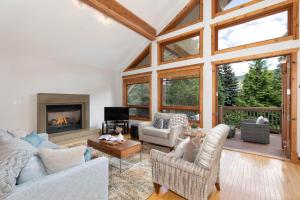 a living room filled with furniture and a fireplace at Meadow Green Chalet - Family Chalet, Golf Course, Hot Tub, BBQ, Garden - Whistler Platinum in Whistler