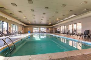 a pool with chairs and tables in a building at Drury Inn & Suites St Joseph in Saint Joseph