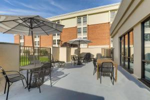 a patio with tables and chairs and umbrellas at Drury Inn & Suites St Joseph in Saint Joseph