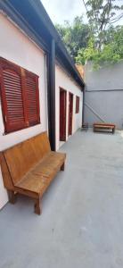 drewniana ławka siedząca na boku budynku w obiekcie Hostel Mariscal w mieście Corrientes