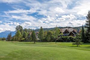 a house on a golf course with mountains in the background at Goldenwood 8337 - Golf Course View, Sun-Deck, Hot Tub, Secure Garage - Whistler Platinum in Whistler