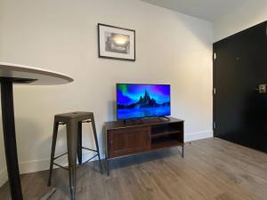 a living room with a flat screen tv on a wooden cabinet at Lovely 1 Bedroom Condo Free Parking And Balcony in Edmonton