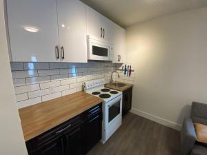 a small kitchen with a stove and a microwave at Lovely 1 Bedroom Condo Free Parking And Balcony in Edmonton