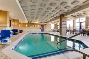 uma piscina no átrio do hotel com cadeiras e mesas em Drury Inn & Suites St. Louis St. Peters em Saint Peters