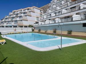 a swimming pool in front of a large apartment building at AMADORES BEACH VIEW APARTMENT in Amadores