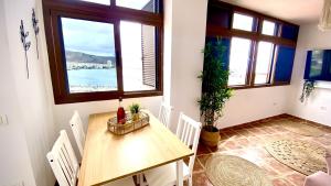 阿羅納的住宿－Atardecer Rosa Sobre el Mar By Deihu Experiencias，一间带桌椅和窗户的用餐室