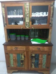 een houten kast met groene kommen erin bij Casa de Praia Balneário Piçarras in Piçarras